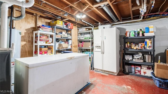 basement featuring white refrigerator with ice dispenser and refrigerator