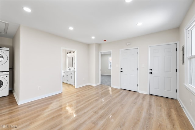 interior space with light wood-type flooring and stacked washer / dryer