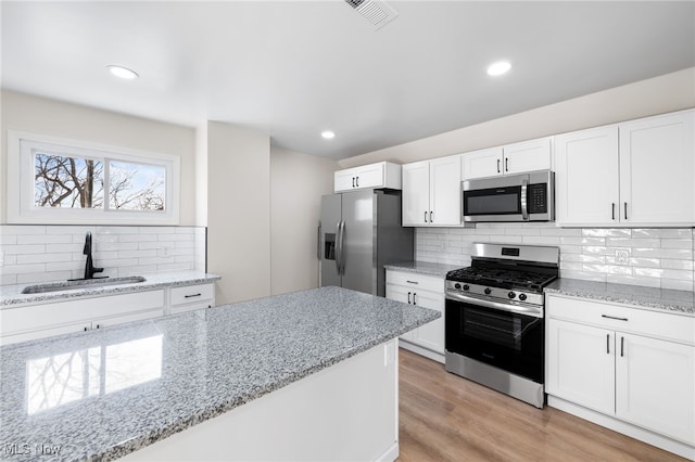 kitchen featuring white cabinets, light hardwood / wood-style floors, sink, and appliances with stainless steel finishes