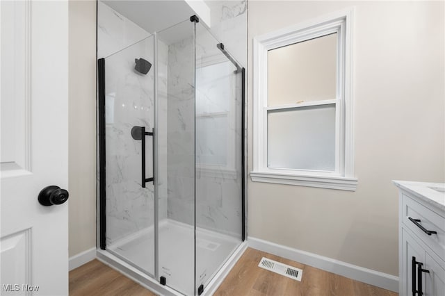 bathroom with vanity, wood-type flooring, and walk in shower