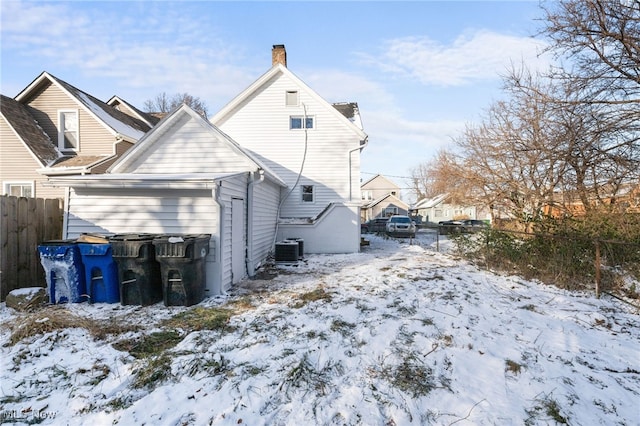 snow covered rear of property featuring central air condition unit