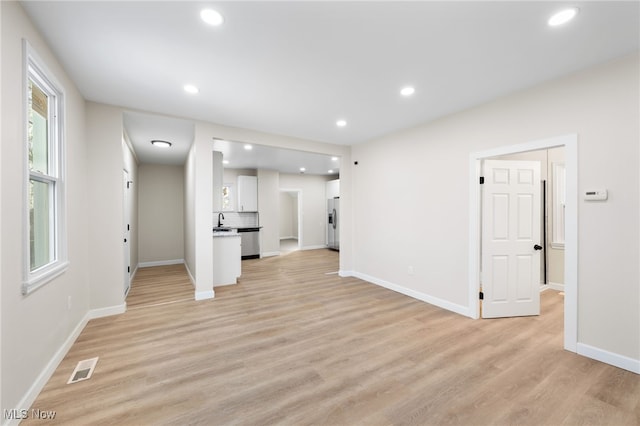 unfurnished living room featuring light hardwood / wood-style floors and sink