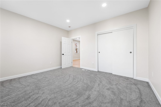 unfurnished bedroom featuring carpet floors and a closet