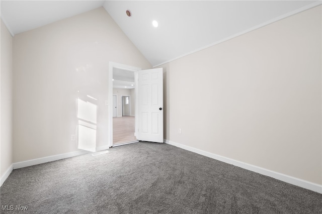 carpeted spare room featuring high vaulted ceiling