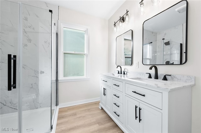 bathroom with hardwood / wood-style flooring, vanity, and walk in shower