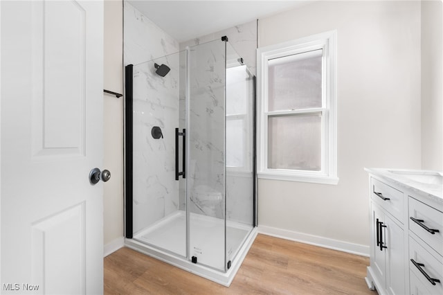 bathroom with a shower with door, vanity, and wood-type flooring