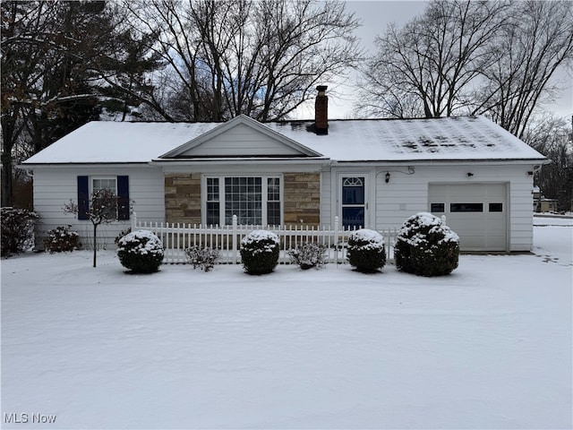 snow covered rear of property with a garage