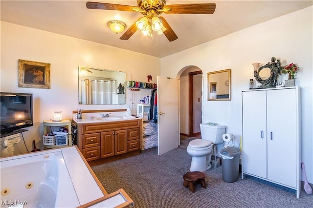 bathroom featuring vanity, toilet, a bathtub, and ceiling fan