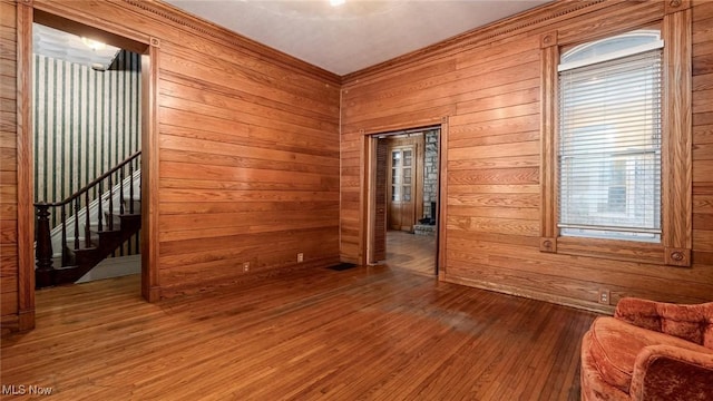 empty room with hardwood / wood-style flooring and wood walls