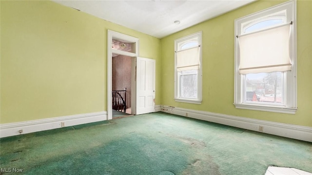 unfurnished bedroom featuring carpet floors, baseboard heating, and multiple windows