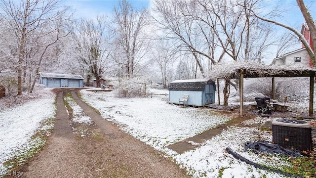 yard layered in snow featuring central air condition unit and a shed