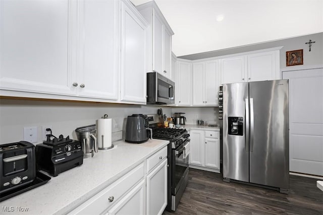 kitchen featuring dark wood-type flooring, stainless steel appliances, and white cabinets