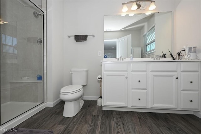 bathroom featuring vanity, toilet, a shower with door, and hardwood / wood-style floors