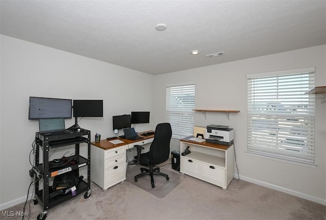 carpeted office featuring a textured ceiling