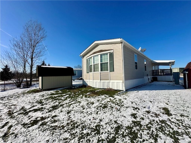 view of snowy exterior featuring a shed