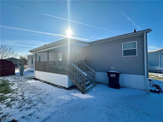 snow covered house with a storage unit