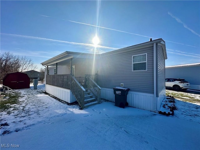 view of snow covered back of property