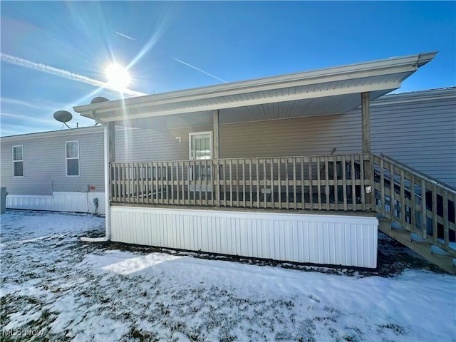 view of snow covered back of property