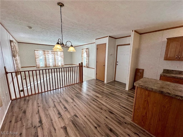 dining space with a notable chandelier, crown molding, a textured ceiling, and hardwood / wood-style flooring