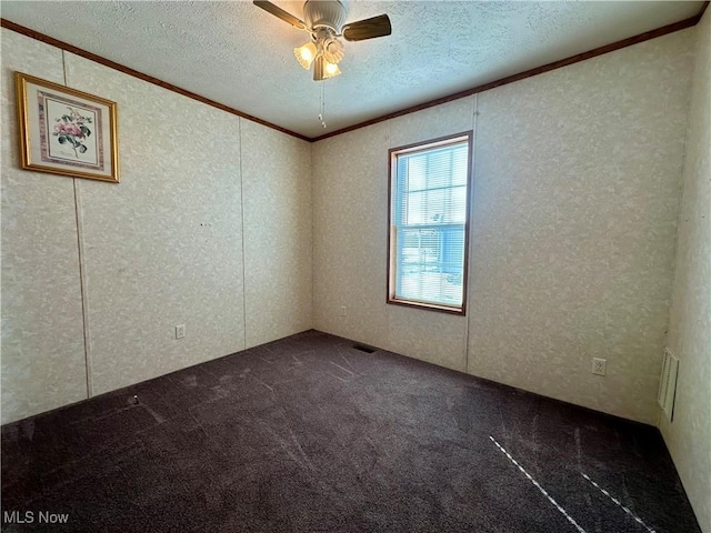 unfurnished room with dark colored carpet, a textured ceiling, ceiling fan, and ornamental molding