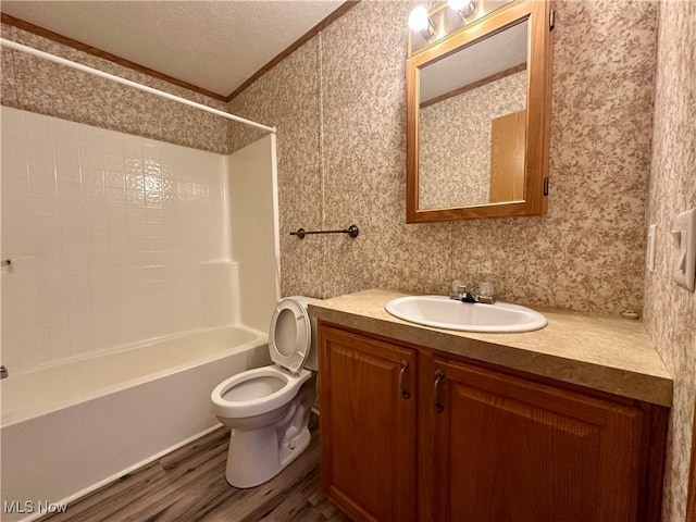 full bathroom featuring vanity, a textured ceiling, crown molding, wood-type flooring, and shower / tub combination