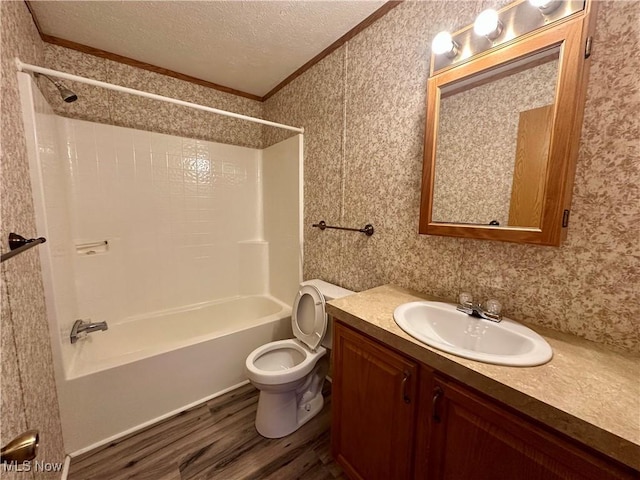 full bathroom featuring shower / bathing tub combination, crown molding, toilet, a textured ceiling, and wood-type flooring