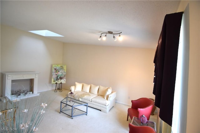 carpeted living room featuring a textured ceiling and a skylight