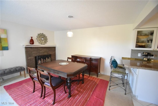 dining room with a textured ceiling and a fireplace