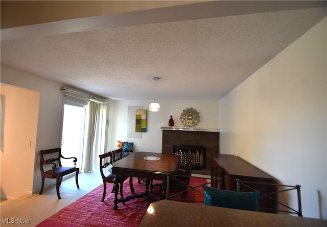 carpeted dining area with a textured ceiling