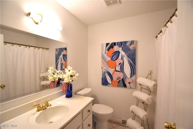 bathroom featuring vanity, a shower with curtain, tile patterned flooring, toilet, and a textured ceiling