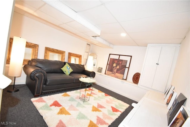 carpeted living room with a drop ceiling