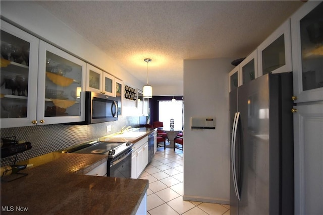 kitchen with stainless steel appliances, backsplash, a textured ceiling, decorative light fixtures, and white cabinets