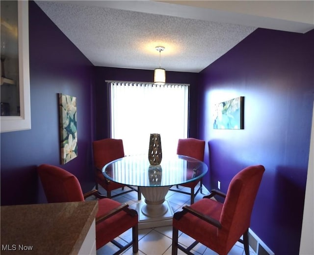 dining area featuring tile patterned flooring and a textured ceiling