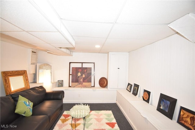 carpeted living room featuring a paneled ceiling