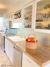 7355 W Blvd, Youngstown, OH 44512 - kitchen with white cabinets, appliances with stainless steel finishes, a sink, and glass insert cabinets