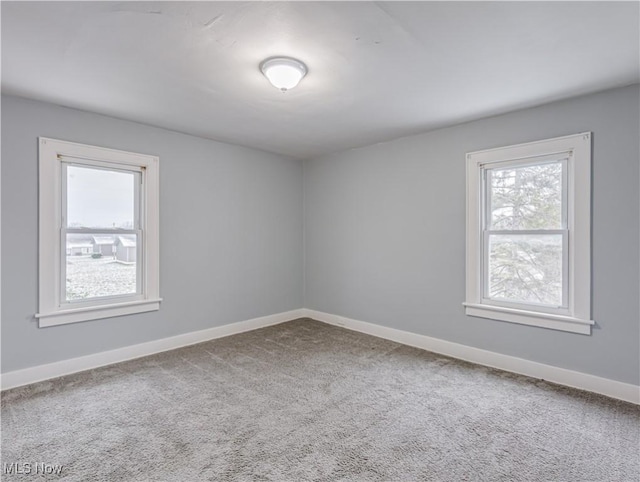 unfurnished room with baseboards and carpet floors