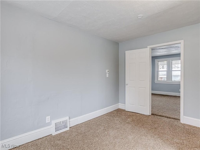 unfurnished room featuring carpet flooring and a textured ceiling