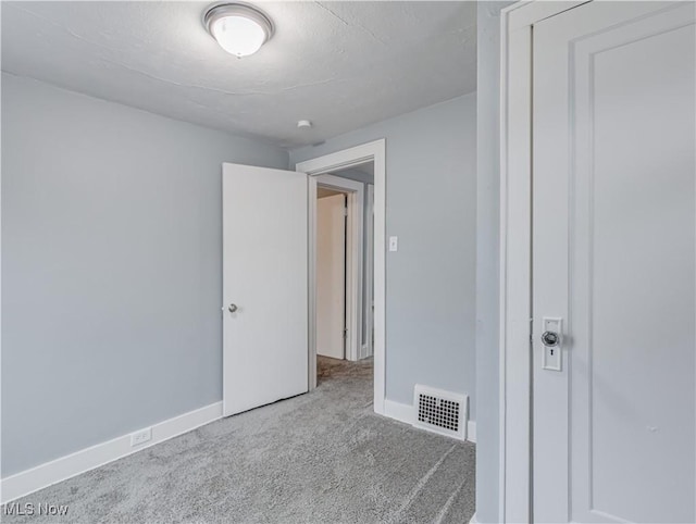 unfurnished bedroom featuring carpet flooring, baseboards, and visible vents