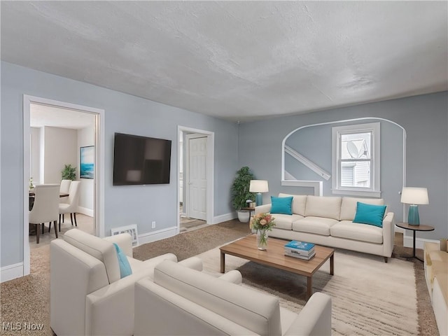 carpeted living room featuring baseboards