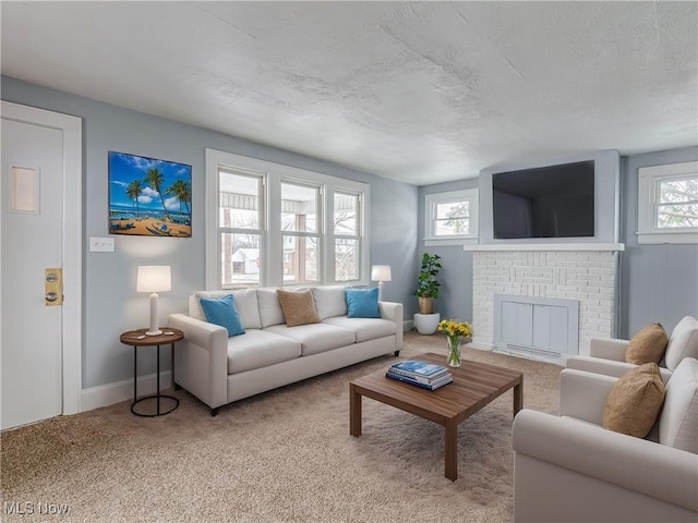 carpeted living room with a brick fireplace and baseboards