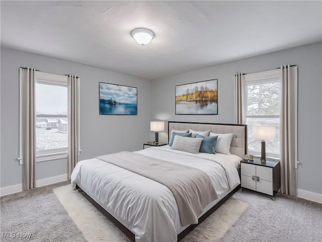 bedroom featuring light carpet and baseboards