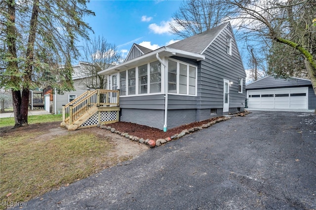 view of front of house with a sunroom, an outbuilding, and a garage