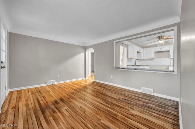 unfurnished living room with hardwood / wood-style flooring and ceiling fan