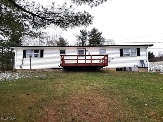 back of property featuring a lawn and a deck