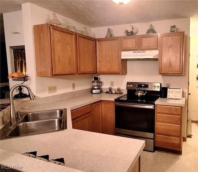 kitchen with a textured ceiling, stainless steel electric range oven, and sink