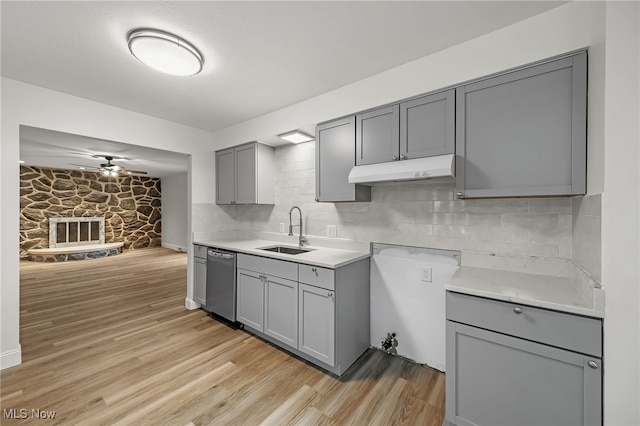 kitchen featuring gray cabinets, dishwasher, sink, and light wood-type flooring