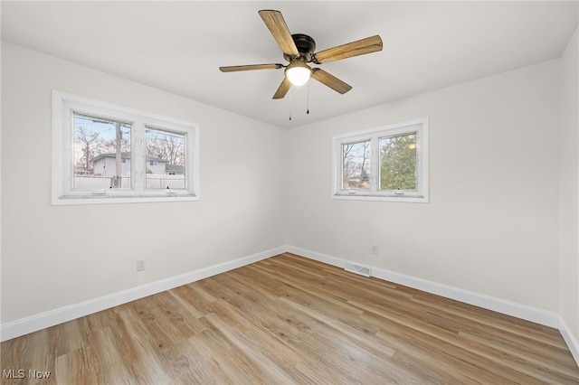 unfurnished room featuring ceiling fan, light hardwood / wood-style floors, and a wealth of natural light