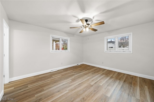 empty room with ceiling fan and light hardwood / wood-style floors