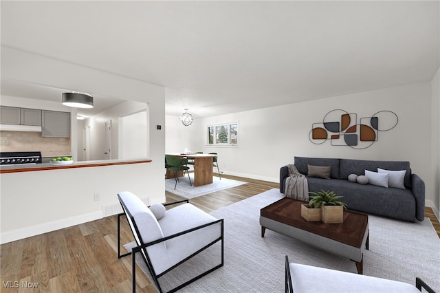 living room featuring wood-type flooring and an inviting chandelier