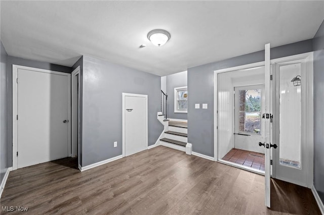 entryway featuring wood finished floors, french doors, baseboards, and stairs